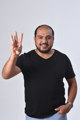Fototapeta premium latin man with finger in the shape of number 3