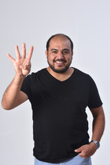 Fototapeta premium latin man with finger in the shape of number four