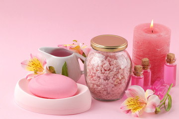 Spa. Aromatherapy. Body care cosmetics. Handmade soap and aroma oil and sea salt on a gentle pink background