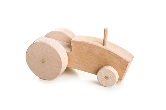 Homemade wooden tractor toy on white background.