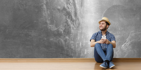 Young man sitting on floor, a moment for relax concept. Mixed media