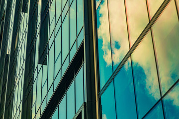 Sky with clouds reflected in windows of modern office building. Colorful background.