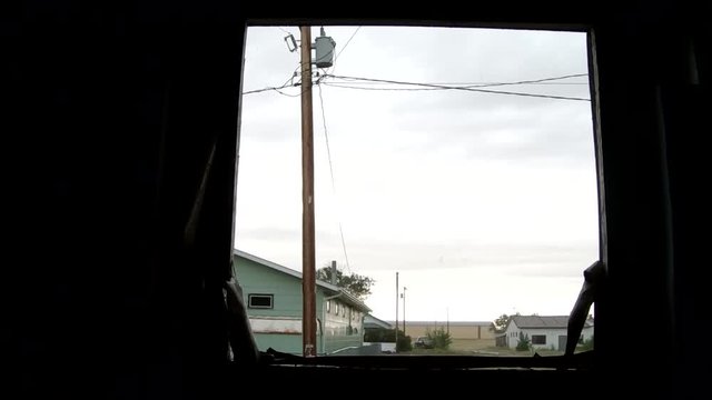 Looking through a broken window on a rainy day in a abandoned house.