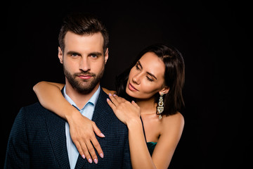 Close up photo beautiful tender she her wife earrings he him his husband married spouse celebrities piggyback pose hold hands arms chest wear costume jacket green dress isolated black background