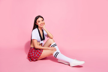 Portrait of her she nice-looking attractive charming cute lovely lovable slender cheerful cheery straight-haired lady sitting on floor isolated on pink pastel background