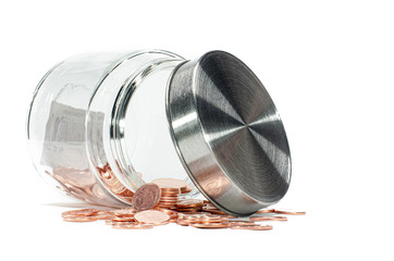 Thai copper coins spilling out of a glass jar , isolated on a white background