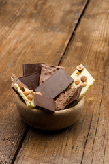 mixed chocolate chunks in wooden bowl on table