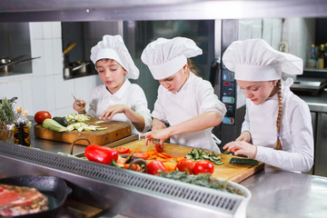 children cooking lunch in a restaurant kitchen.