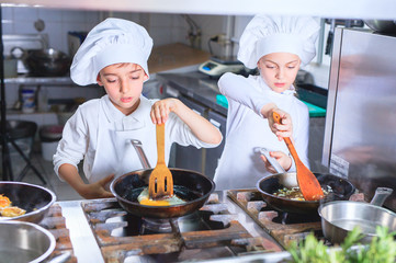 children cooking lunch in a restaurant kitchen.