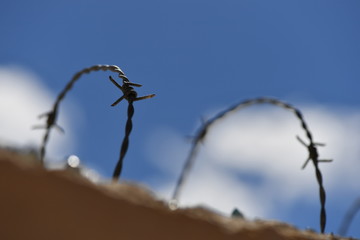 Partial view of barbed wire on an old spanish house wall.
