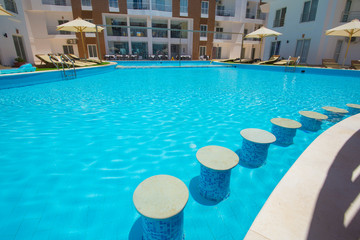 Swimming pool with bar in a luxury tropical hotel apartment resort
