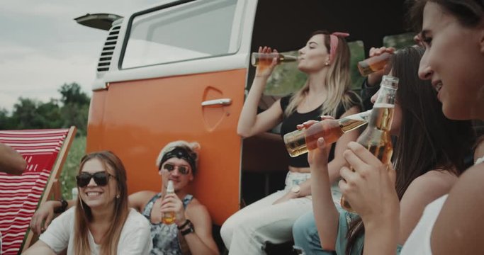 Party time in the middle of field group of 90 s friends cheers with the bottles of beer , stylish and happy faces. 4k