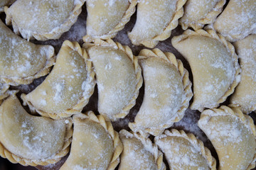 Vareniks are sprinkled with flour on the tray