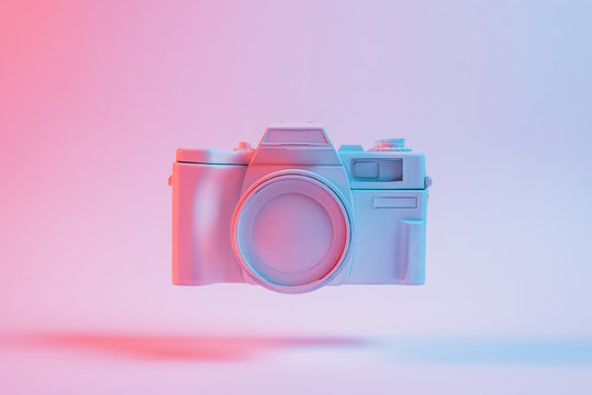 Painted Camera Floating With Shadow Against Pink Backdrop