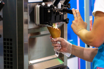 Preparation of creamy fruit ice cream from ice cream machine in shopping center