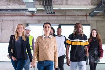 Obraz premium young multiethnic business people walking through unfinished startup office