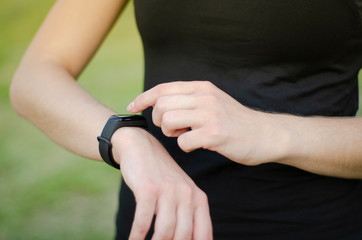 Obraz premium A young girl uses a fitness tracker. Smartwatch.