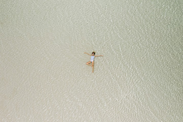 Woman Floating In Crystal Clear Lagoon Water