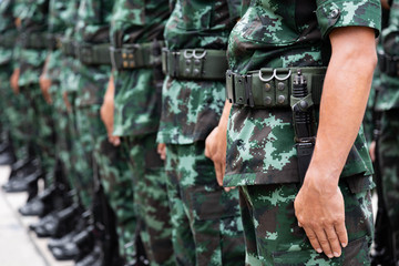 Fototapeta premium The Army soldier stand row they are wear hat and wear Military vest.