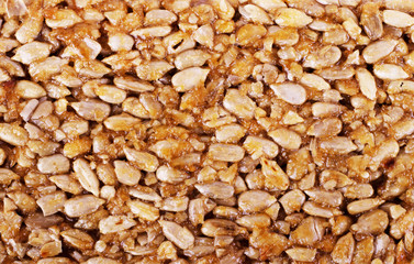 Kozinaki from golden, roasted peanuts beans as a background, texture. Macro shooting, close-up.