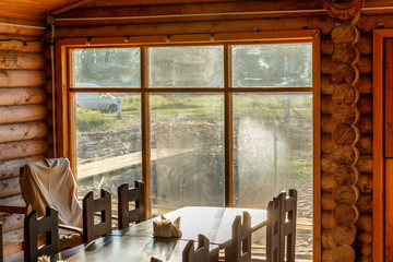 Wooden cafe interior with sea view through dirty glass windows.