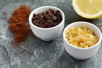 Lip or body scrubs in small bowl with coffee and lemon peel, homemade skin care.