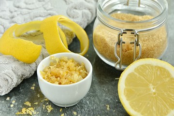 Homemade lemon peel and sugar lip scrub in small bowl and ingredients.