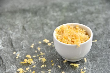 Diy lip scrub made with lemon peel and brown sugar in small bowl, copy space.