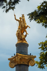 Fototapeta premium Gilded statue of St. George against the cloudy sky,