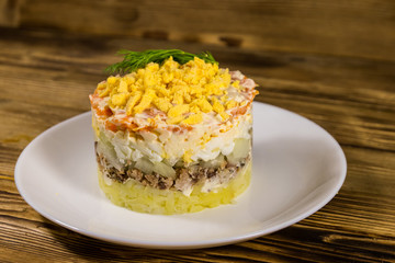 Traditional russian salad Mimosa on wooden table
