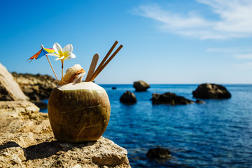 Coconut Water fresh cocktail in natural coconut healthy drink on blue sea background copy space