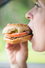 Woman eating hamburger closeup