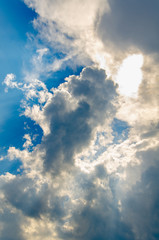 Dramatic cloudscape. Sky background with gray clouds and sunlight