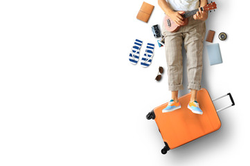 Tourist concept, a man with a guitar put her feet on the suitcase