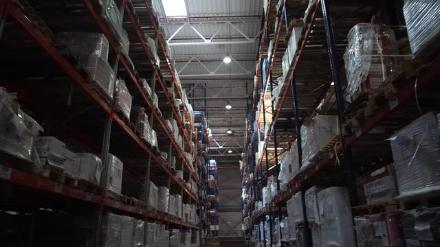 Logistics warehouse. Shelving with products. A lot of boxes on the shelves. Camera in motion. 4K Slow Mo