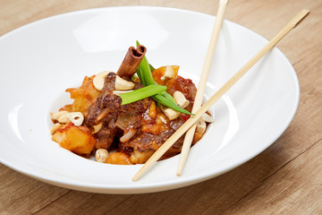 asian dish with meat on wooden table