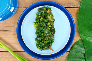 Braised exotic edible plant recipe (Xanthosoma sagittifolium) called taioba in Brazil in wood...