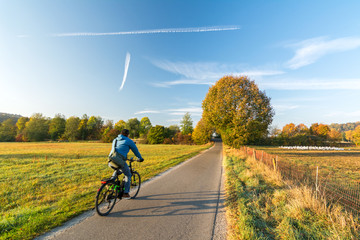 Cyclist on a bike lane in rural landscape in the fall