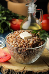 Buckwheat. Porridge with a piece of butter in a glass plate on a blue wooden table. breakfast, healthy food.