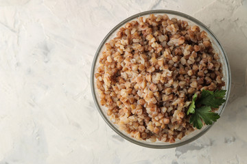 Buckwheat. Porridge cereals in a glass plate on a bright table. breakfast, healthy food. top view