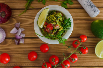 guacamole and fresh vegetables on wooden table