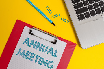 Word writing text Annual Meeting. Business photo showcasing Yearly gathering of an organization interested shareholders Open laptop clipboard blank paper sheet marker clips colored background