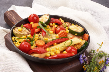 Grilled vegetables in a cast iron grilling pan on a rustic background