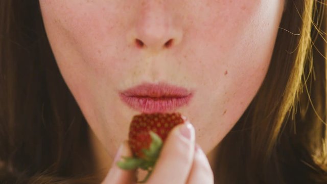 Beautiful, female lips with appetite eat ripe strawberries. Close up.Very beautiful studio shot. Slow motion. Camera Arri Alexa.