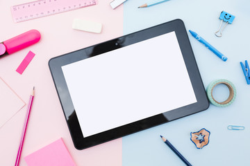 Tablet with stationery around on colorful background