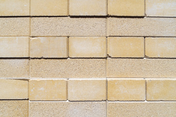 Bricks neatly stacked on a construction site. Creative vintage background in yellow and brown.