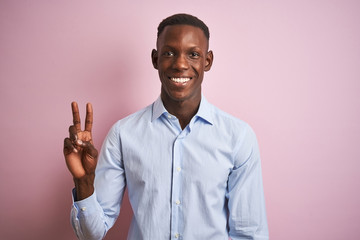 African american man wearing blue elegant shirt standing over isolated pink background showing and pointing up with fingers number two while smiling confident and happy.