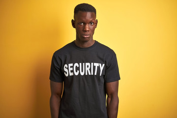 African american safeguard man wearing security uniform over isolated yellow background skeptic and nervous, frowning upset because of problem. Negative person.