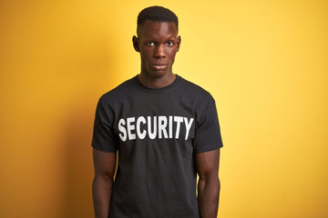African american safeguard man wearing security uniform over isolated yellow background skeptic and...