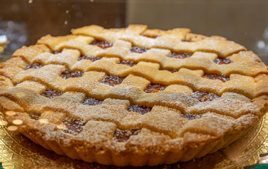 Crostata, pie with apricot jam and white sugar.